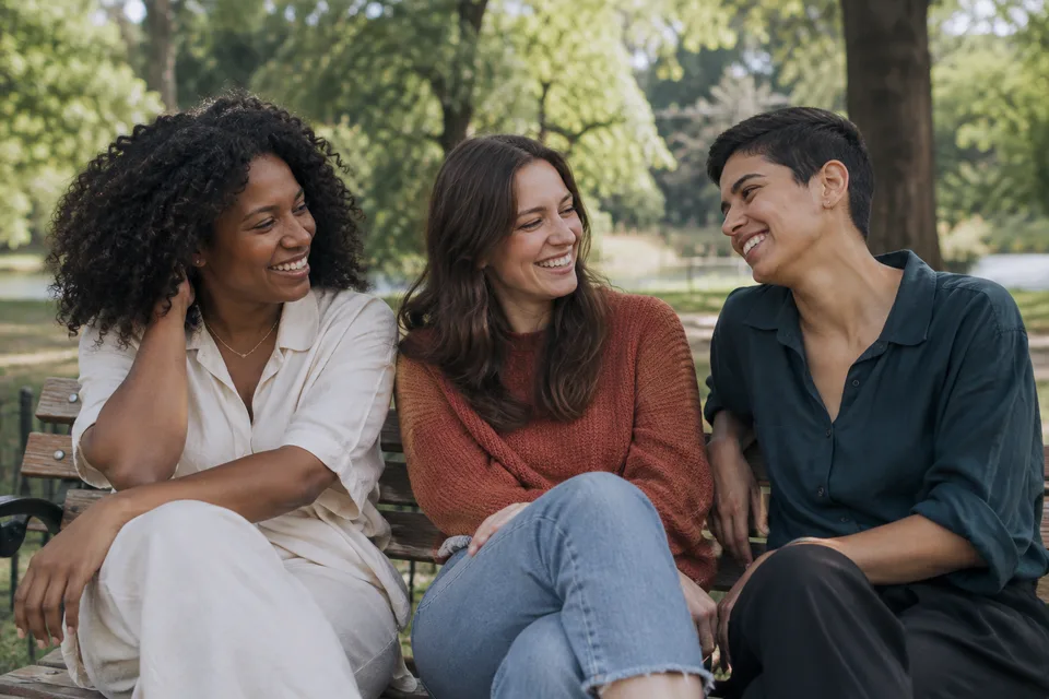Three friends sharing a laugh in the park